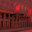 Fasadbild av Uppsala Stadsteater med färgglada flaggor